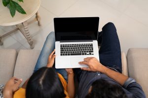 A couple sit together as they type on a laptop. Online therapy in the United Kingdom can help individuals and couples from the comfort of home. Contact an online therpaist in the UK to learn more about online anxiety therapy and other services. 60604 