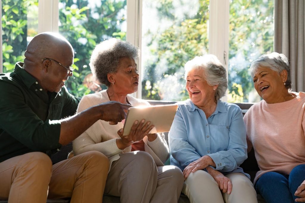 Happy diverse group of senior friends having fun together. Make an effort to make adult friends! An online therapist in the UK can help you learn how. Reach out now!