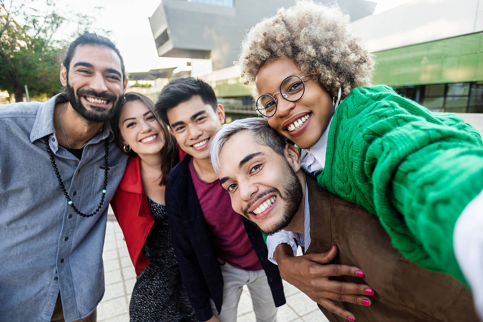 Group of diverse friends in the city taking a selfie together. Making friends as an adult can be tough. Therapy for life transitions, expat therapy and anxiety treatment in the UK can be helpful with a skilled London Counsellor.